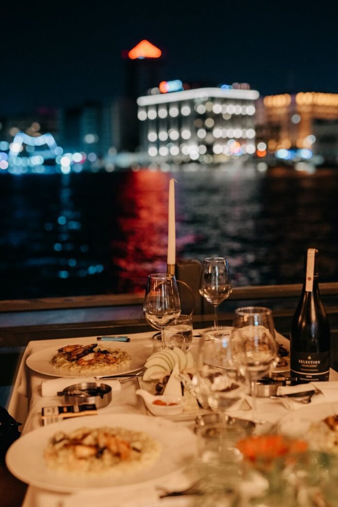 romantic dinner on table by water at night