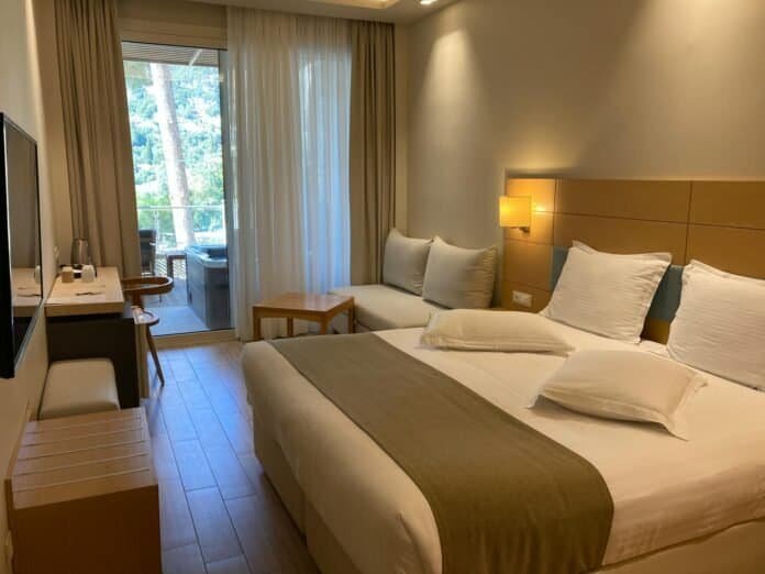 Quarto de hotel aconchegante com cama confortável e vista para a varanda em Pirenópolis.