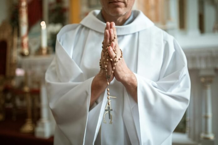 priest with rosary beads